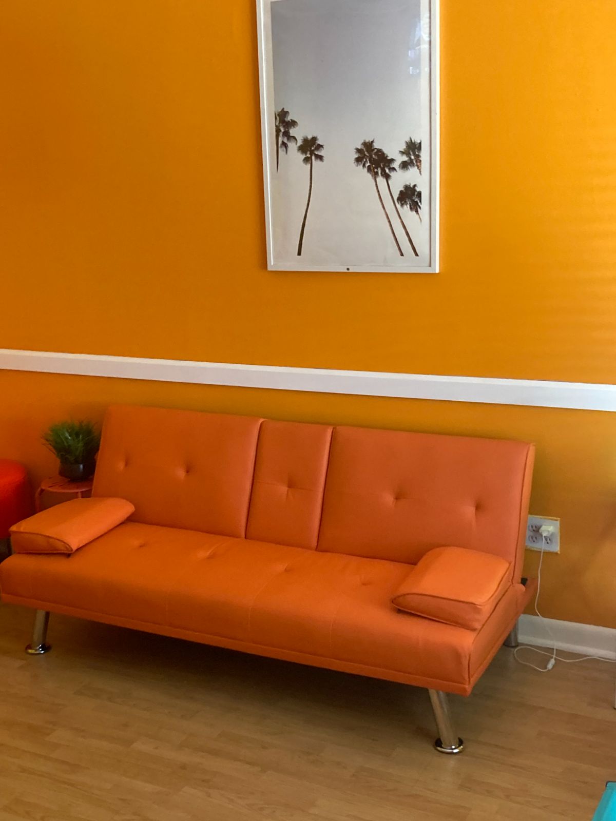 Lounge seating area with orange walls and palm print